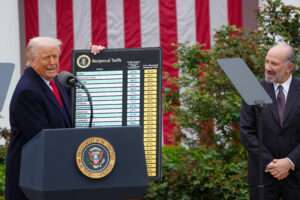 President Donald Trump holds a graph with the list of 