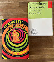 Two copies of the book Exterminate! Regenerate! The Story of Doctor Who, by John Higgs. One, the hardback edition showing an orange Dalek in a series of coloured circles; the other a plainer, green and white proof paperback