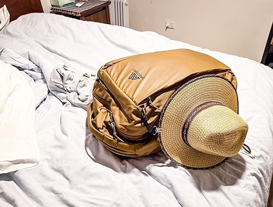 gregory backpack and straw hat sitting on bed