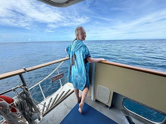 woman on boat wearing ocean armor poncho towel