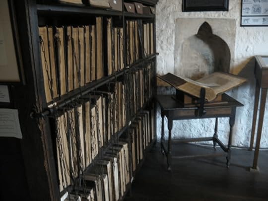 Bookcase of chained books at St Wulfram's with an open book on a stand.