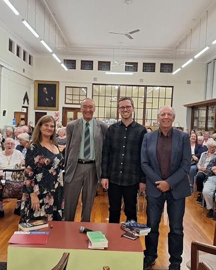 Authors Charity Norman, Cynric Temple-Camp, G. B. Ralph, and Stephen Johnson standing in front of a seated audience at the Whanganui Library.