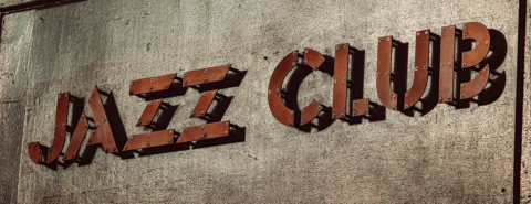Close up of metal sign against concrete that says 