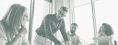 Black and white image of a group meeting at work featuring two men and two woman