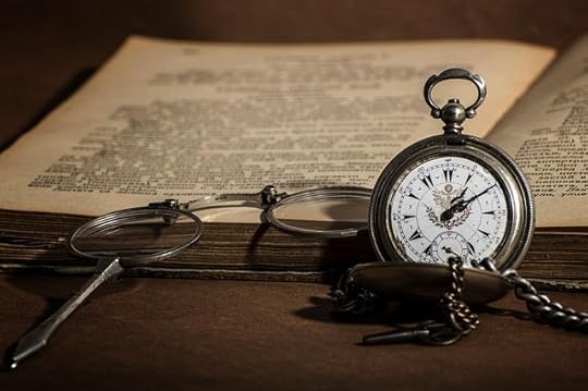 an old book, opened, with a pocket watch and glasses