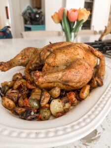 The finished Greek-Inspired Roast Chicken on a bed of vegetables