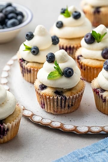 blueberry cupcakes with whipped cream cheese frosting on top with fresh mint.