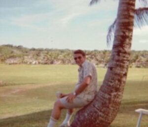 A man sitting on a palm tree trunk