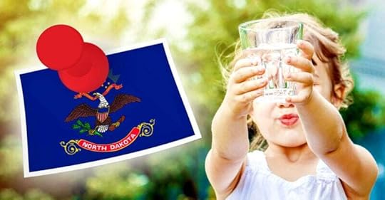 girl holding glass of water and north dakota flag