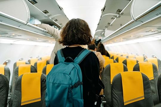 A Young Woman Looking For Her Seat In The Airplain