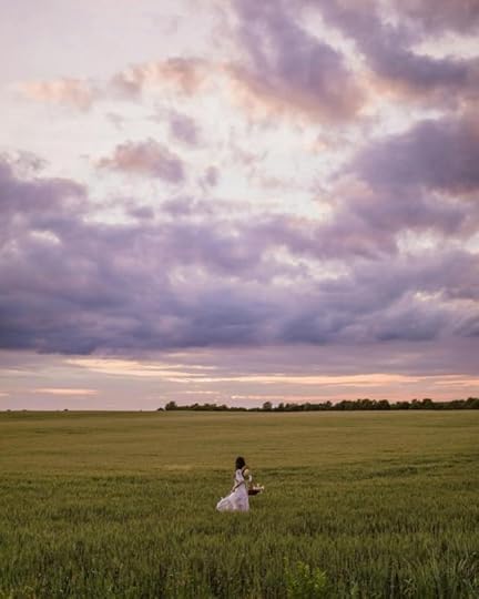 Current image: woman in green field during sunset