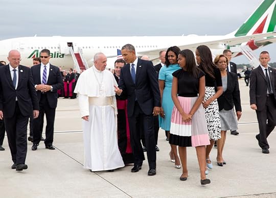 Medium range photo of President Obama and entourage walking off tarmac alongside the Pope, with a plane in the background.
