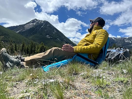 man sitting in crazy creek airlounger in mountains