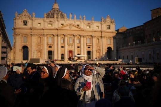 A nun smiles as she waits ahead of the funeral of Pope Francis