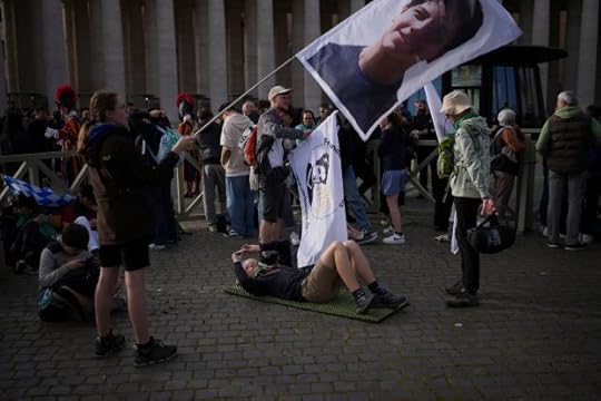 A faithful waves a flag with Carlo Acutis, the 15-year-old Italian boy who died in 2006 of leukemia and beatified in 2020, at the funeral of Pope Francis