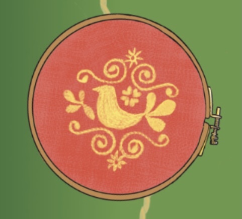 The image of a bird, with spirals and flower decorations above and below it, appears in an embroidery hoop.