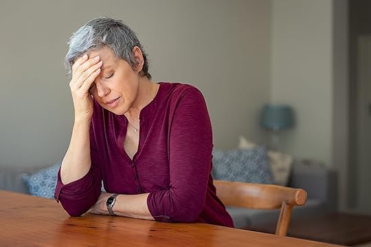 Image of a stressed mature woman resting a hand against her face while sitting at a table. Learn to improve your decision-making skills with the support of DBT used in an Adult IOP in Houston, TX.