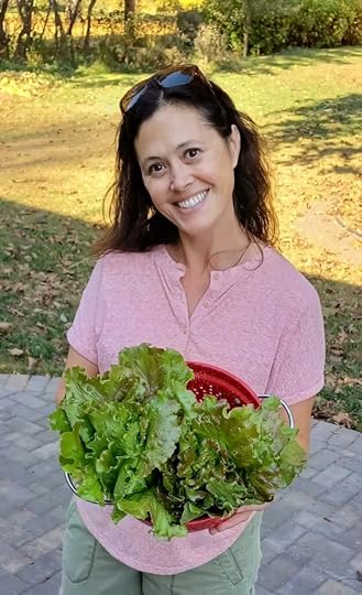 Author and gardener with just harvested heads of lettuce.