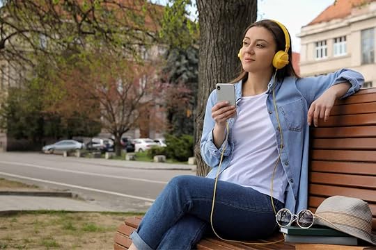 Woman on bench listening to an audiobook on her smartphone