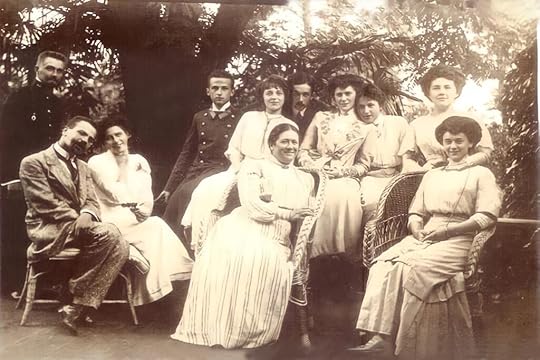 A family in 1910 sitting outside in a garden.