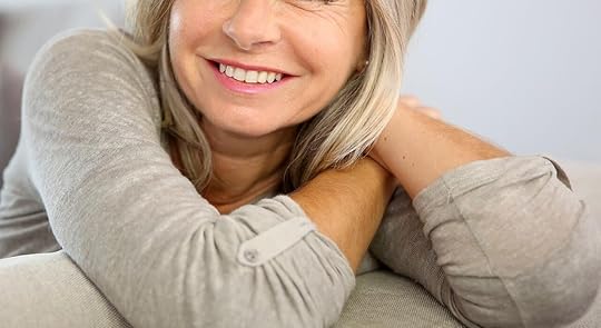 Smiling mature woman sitting on a couch. Begin healing and overcoming the negative unhealthy patterns keeping you from moving forward with an adult IOP in Houston, TX.