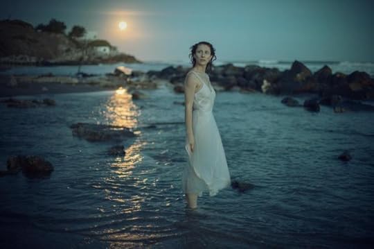 Current image: wet model in dress standing in sea in the evening