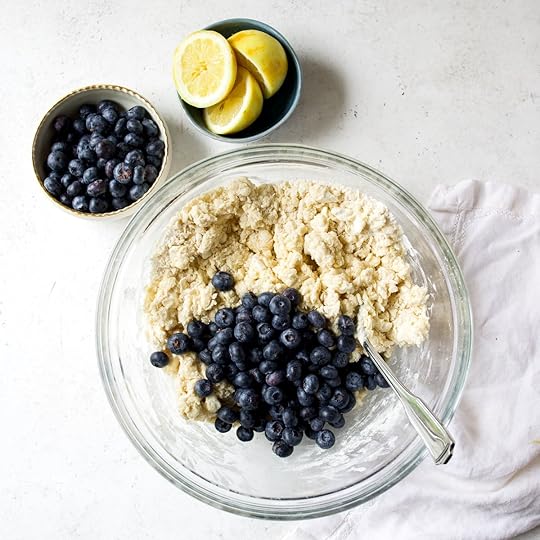 Blueberries sitting on top of scone dough.