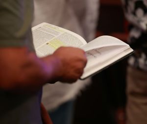 Man holding Bible as he prays