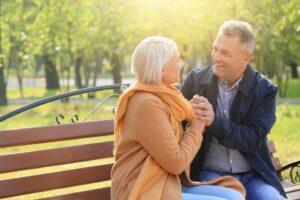older couple sitting on a park bench