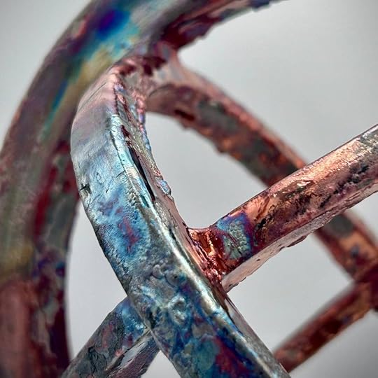 Close-up of a sculptural piece from the 'Liminal Dreams' series, showcasing metallic hues of blue, copper, and iridescent finishes.