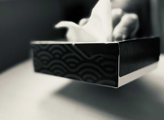 A black and white photo of a small hospital tissue box being slammed on a hospital table.