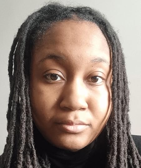 Black woman author headshot, Jackson has a neutral calm expression and is looking at the viewer. Her hair is in dreads and she has a black t-shirt top on.