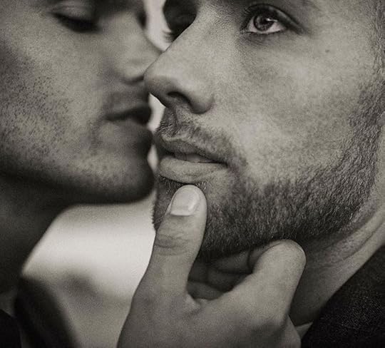 This may contain: two men who are kissing each other with their noses close to one another and looking into the distance