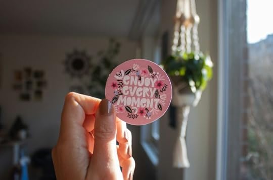 A circular card reading “enjoy every moment.” You find, make, and/or take joy.