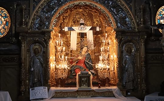 An ornate altar featuring a statue of Our Lady of Sorrows surrounded by candles and decorative elements in a church.