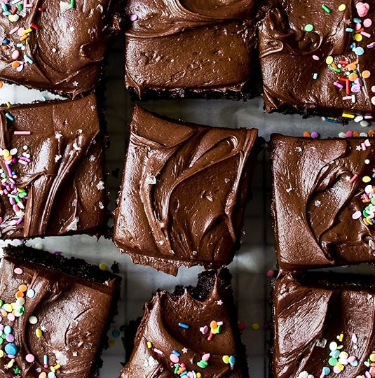 Overhead grid of decadent chocolate homemade cake, generously coated with a luscious dark chocolate glaze, some adorned with playful colorful sprinkles, others with elegant flaky finishing salt, showcasing a delicious homemade treat for any occasion.