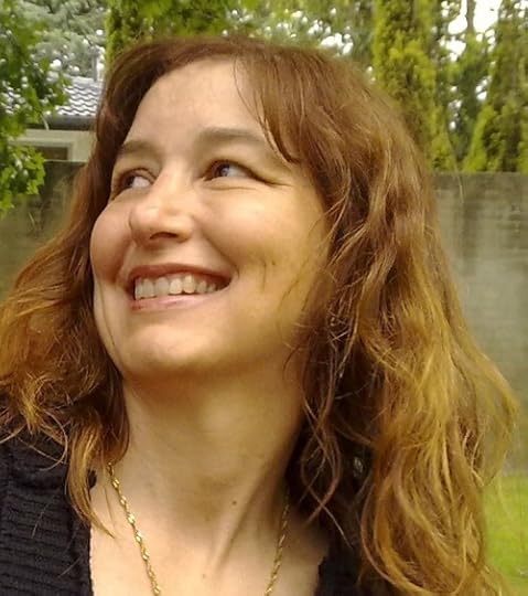 A portrait of author P. L. Matthews. A smiling Caucasian woman gazes over her right shoulder. She has long, wavy blonde hair and a dark sweater with a thin gold chain.