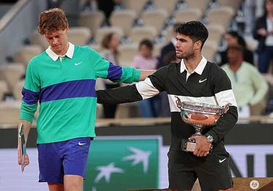 Carlos Alcaraz of Spain holds the Coupe des Mousquetaires trophy as he speaks with runner-up Jannik Sinner of Italy following his victory in the...