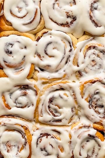 close-up pan of baked and frosted cinnamon rolls.