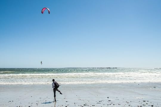 A person on a beach watching someone parasurfing. The Joy of Missing Out - JOMO