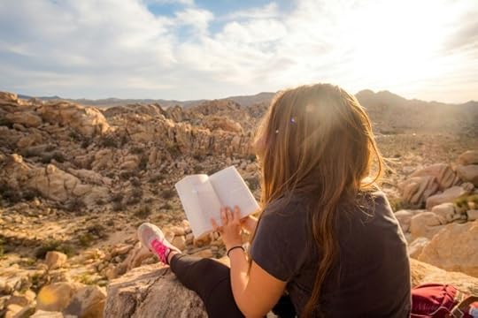 A woman reading a book in rocky terrain. What do you do to find, maintain, and keep an open mind for yourself?