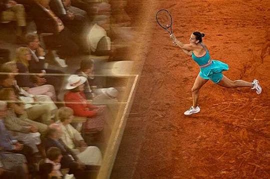 Spectators are reflected in a glass as Belarus' Aryna Sabalenka plays a backhand return to Poland's Iga Swiatek during their women's singles...