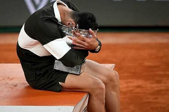 Spain's Carlos Alcaraz embraces the trophy on the podium after winning the men's singles final match against Italy's Jannik Sinner on day 15 of the...
