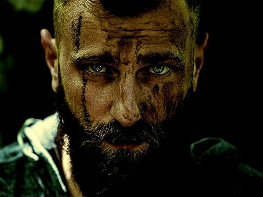 A dirty man with blue eyes staring into the camera