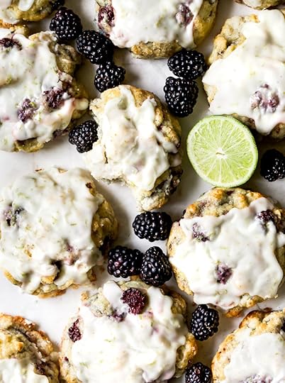 Overhead shot of blackberry scones with zesty lime glaze, fresh blackberries, and a lime wedge.