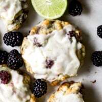 Homemade lime glaze on fluffy blackberry scones with fresh berries.