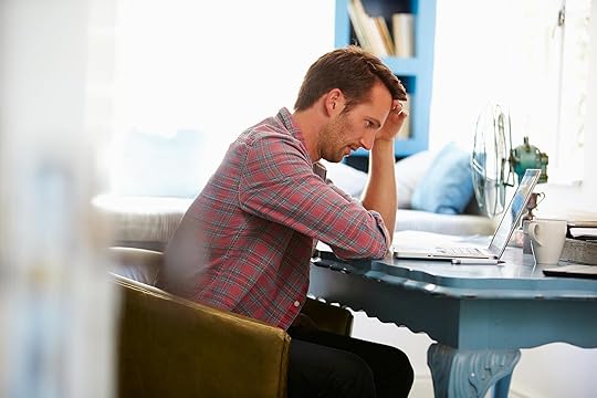Stressed man sitting at a desk resting his hand on his forehead. Begin coping with your anxiety and self-doubt in healthy ways with the help of perfectionism treatment in Houston, TX.