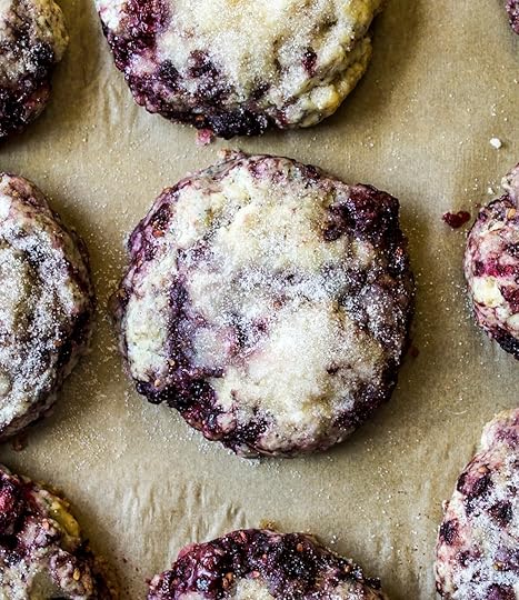Top-down view of freshly bakedblackberry scones with a sugar coatingon light brown parchment paper, showingmoist texture and visible blackberry pieces,homemade fruit scone recipe from DisplacedHousewife.