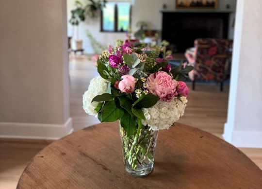 a vase filled with pink and white flowers sitting on a table