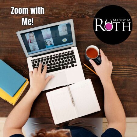 woman's arms on table with laptop open and zoom call in progress